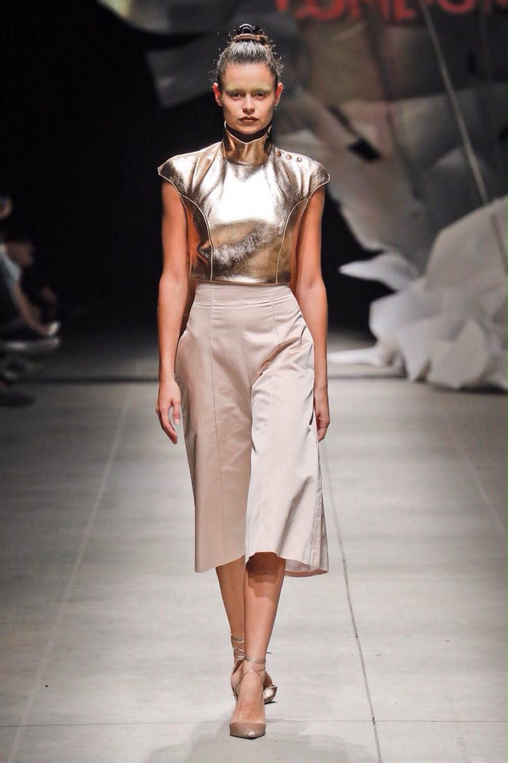 A gold lamé top with a blush culotte skirt on the runway, designed by Federica Cavenati